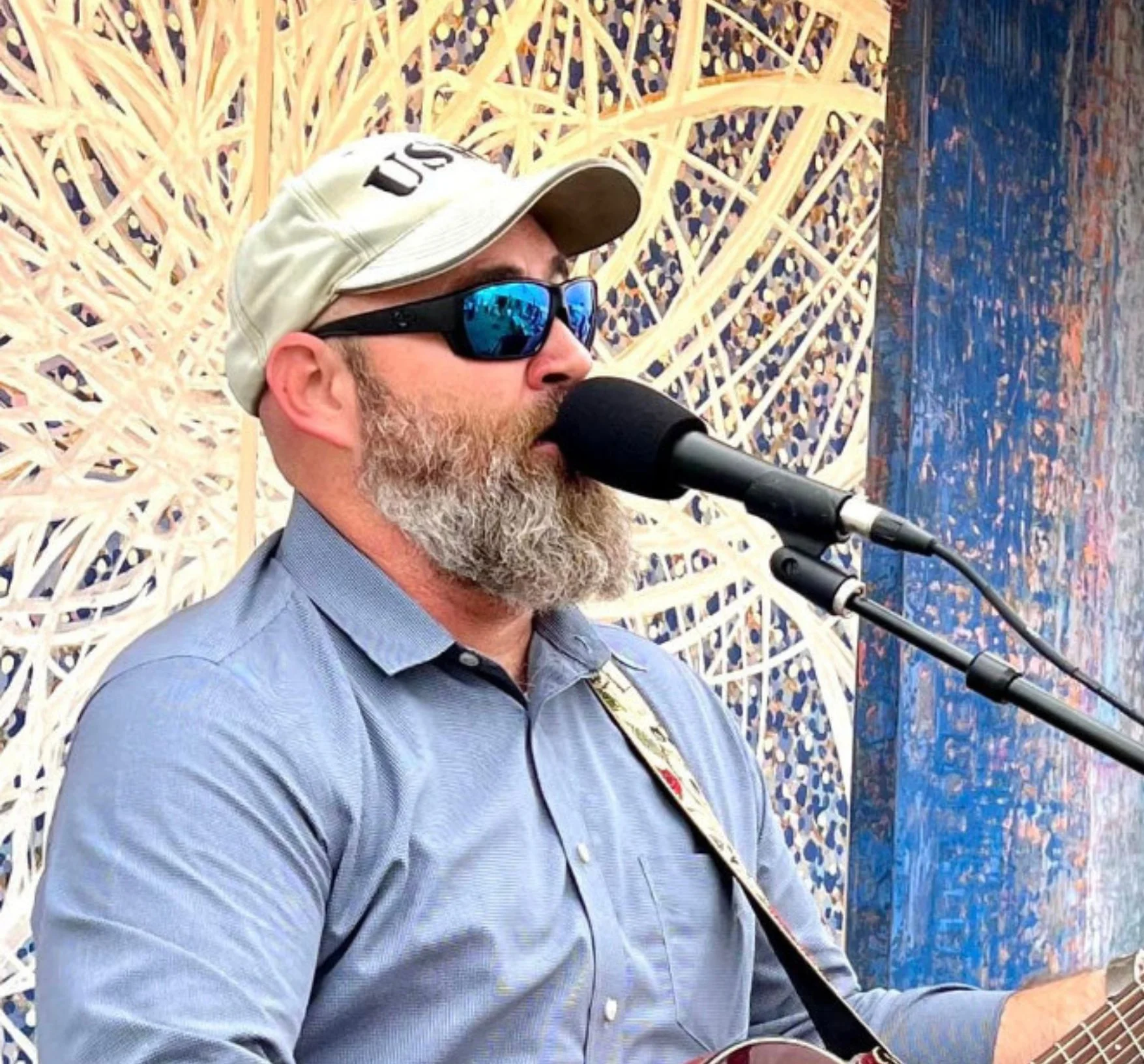 Musician performing live with guitar at an outdoor venue