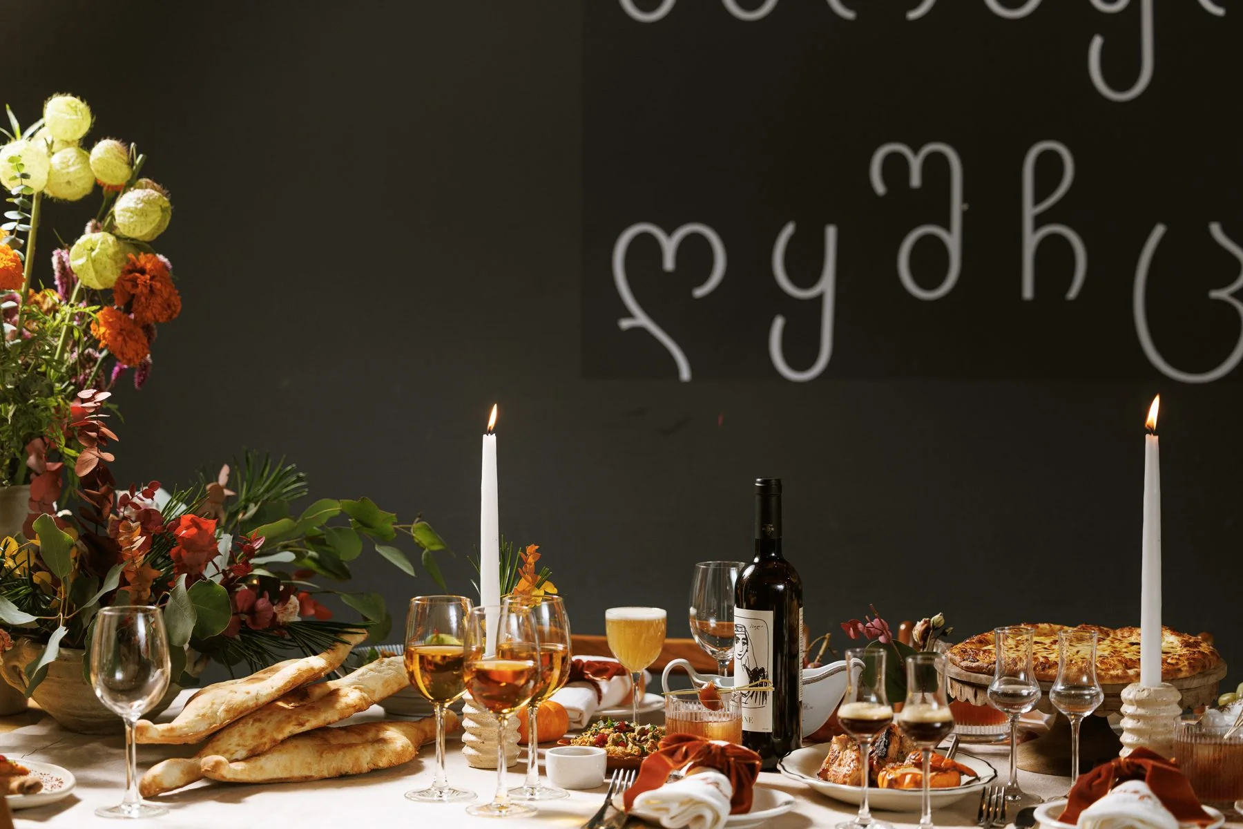 Georgian dishes and wine laid out for a supra