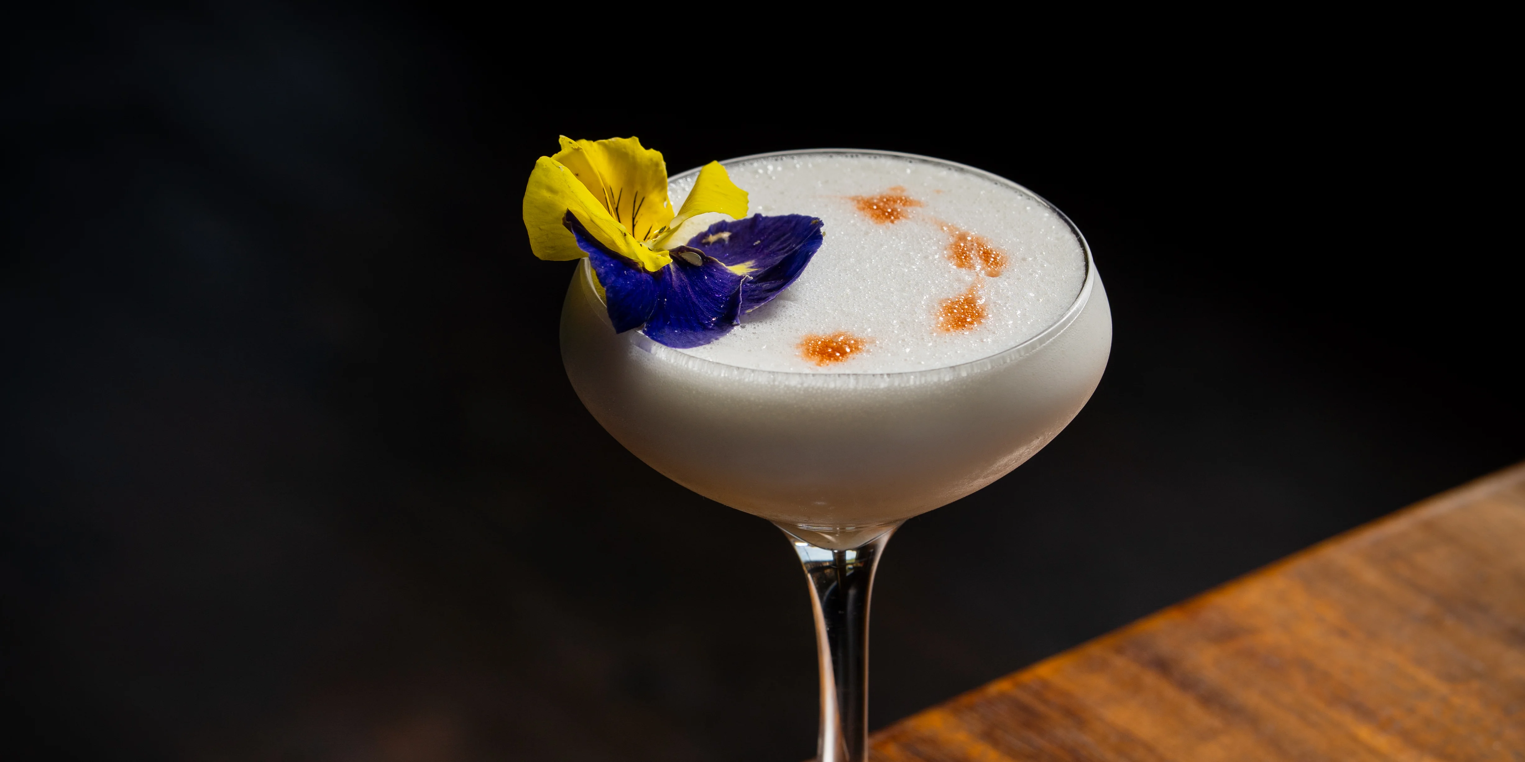 Elegant cocktail garnished with edible flowers