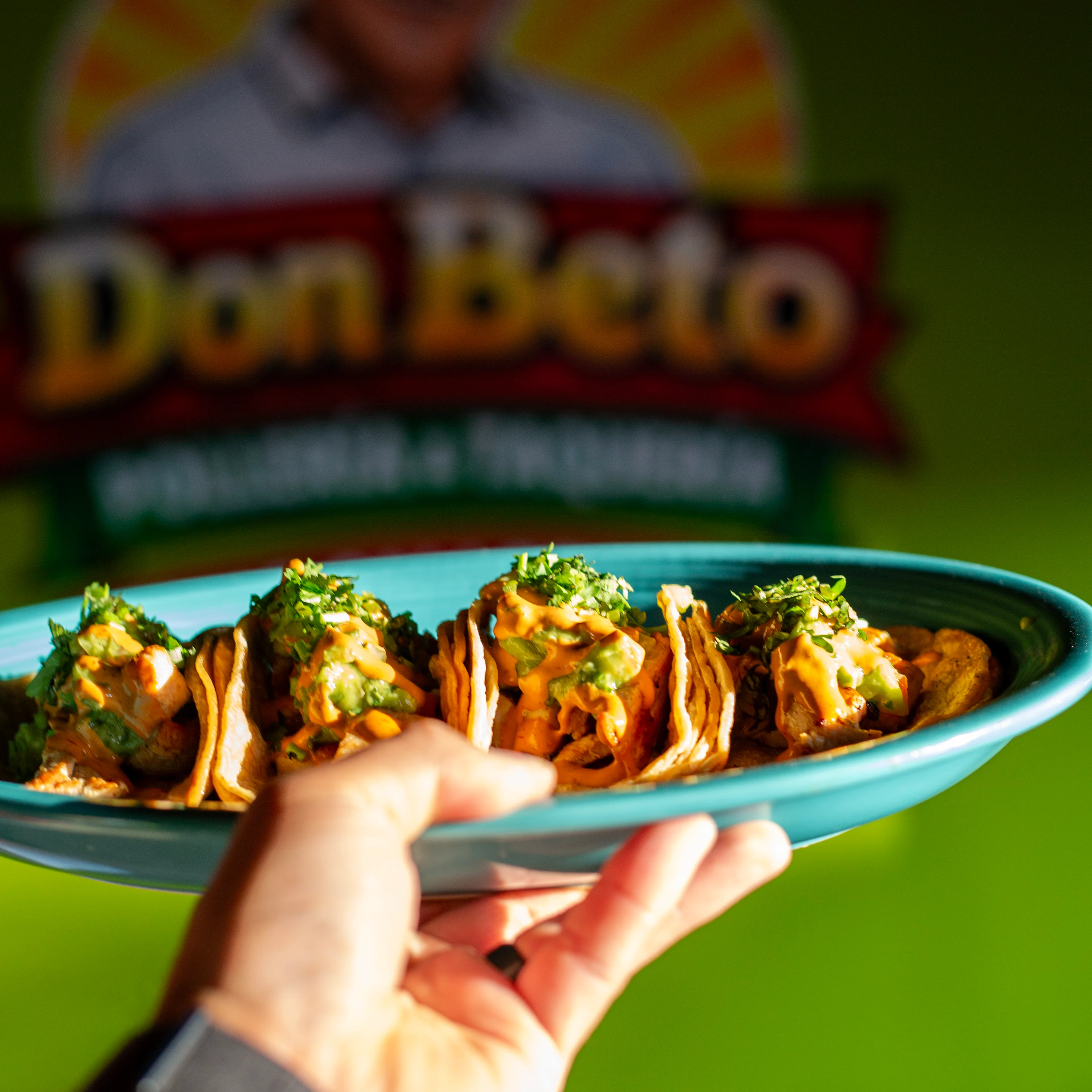 Plate of Mexican street tacos topped with fresh herbs
