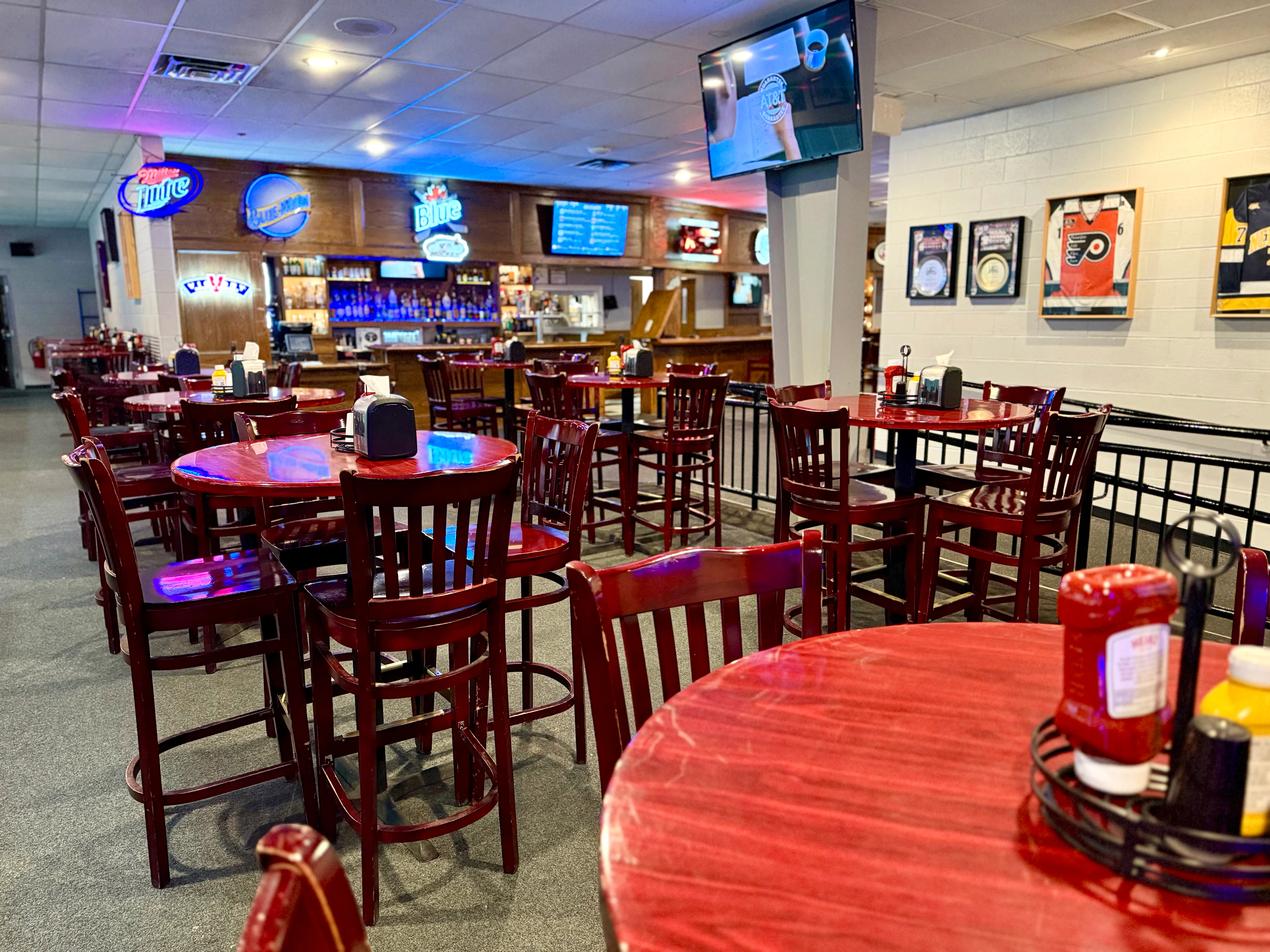 Cozy restaurant interior with red tables and bar area