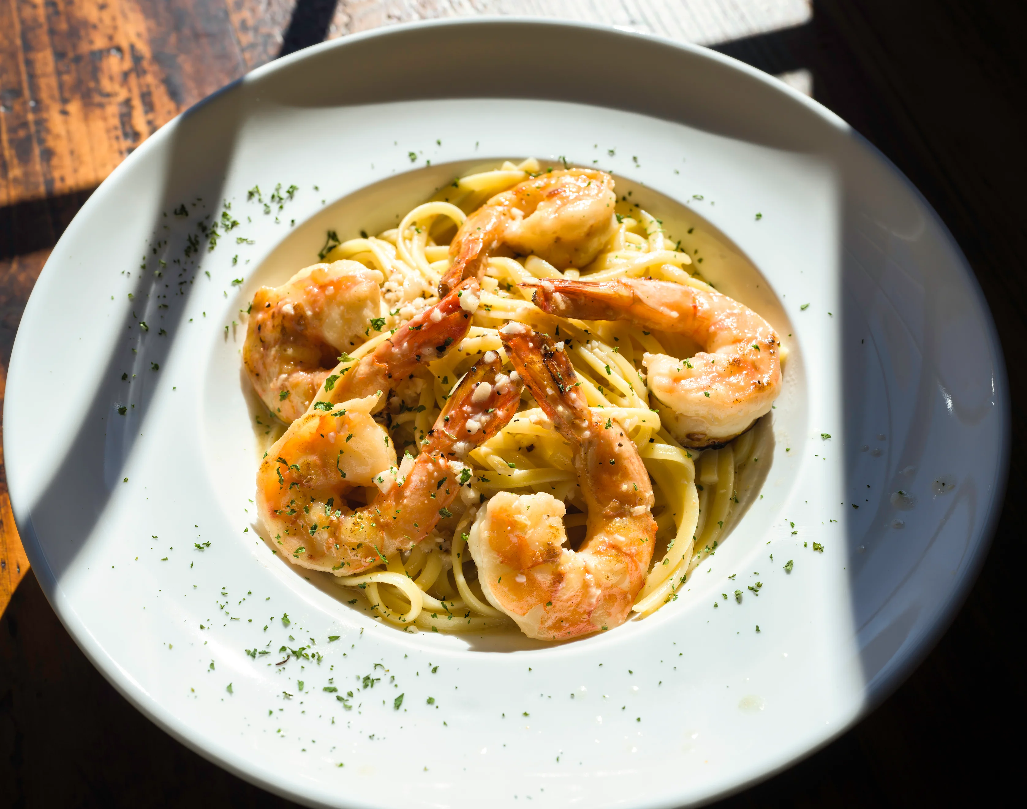 Shrimp linguine with garlic sauce in a white bowl