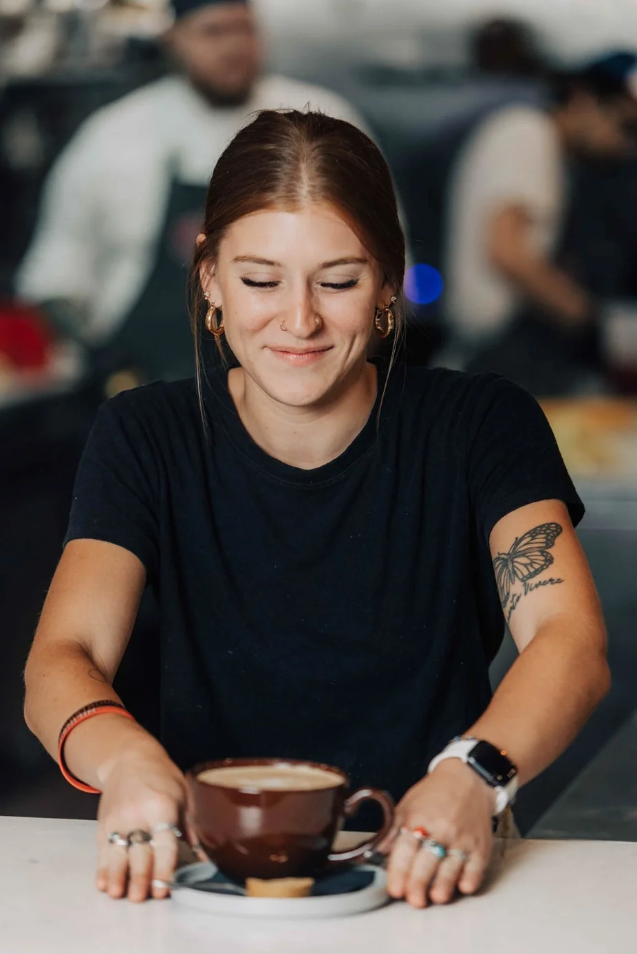 Barista serving a cup of coffee in a cozy café