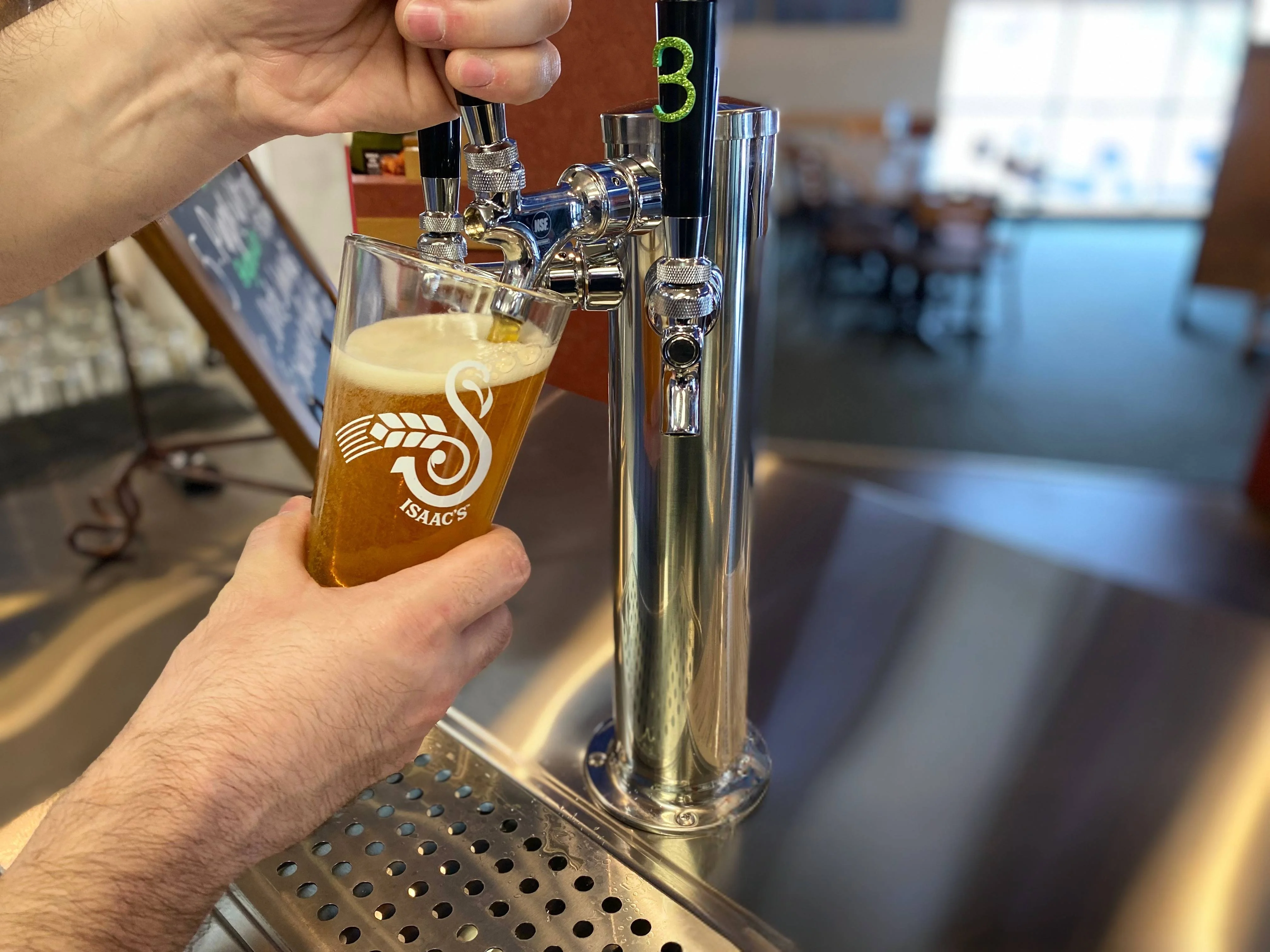 Bartender pouring craft beer into a glass at a bar