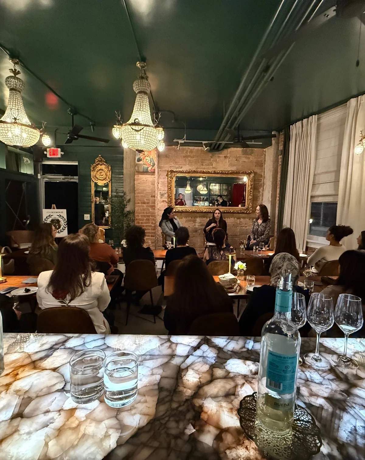 Elegant restaurant interior with chandeliers and guests enjoying an event