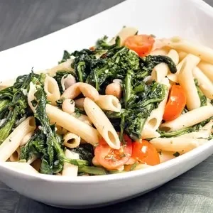 Penne pasta with sautéed greens and cherry tomatoes