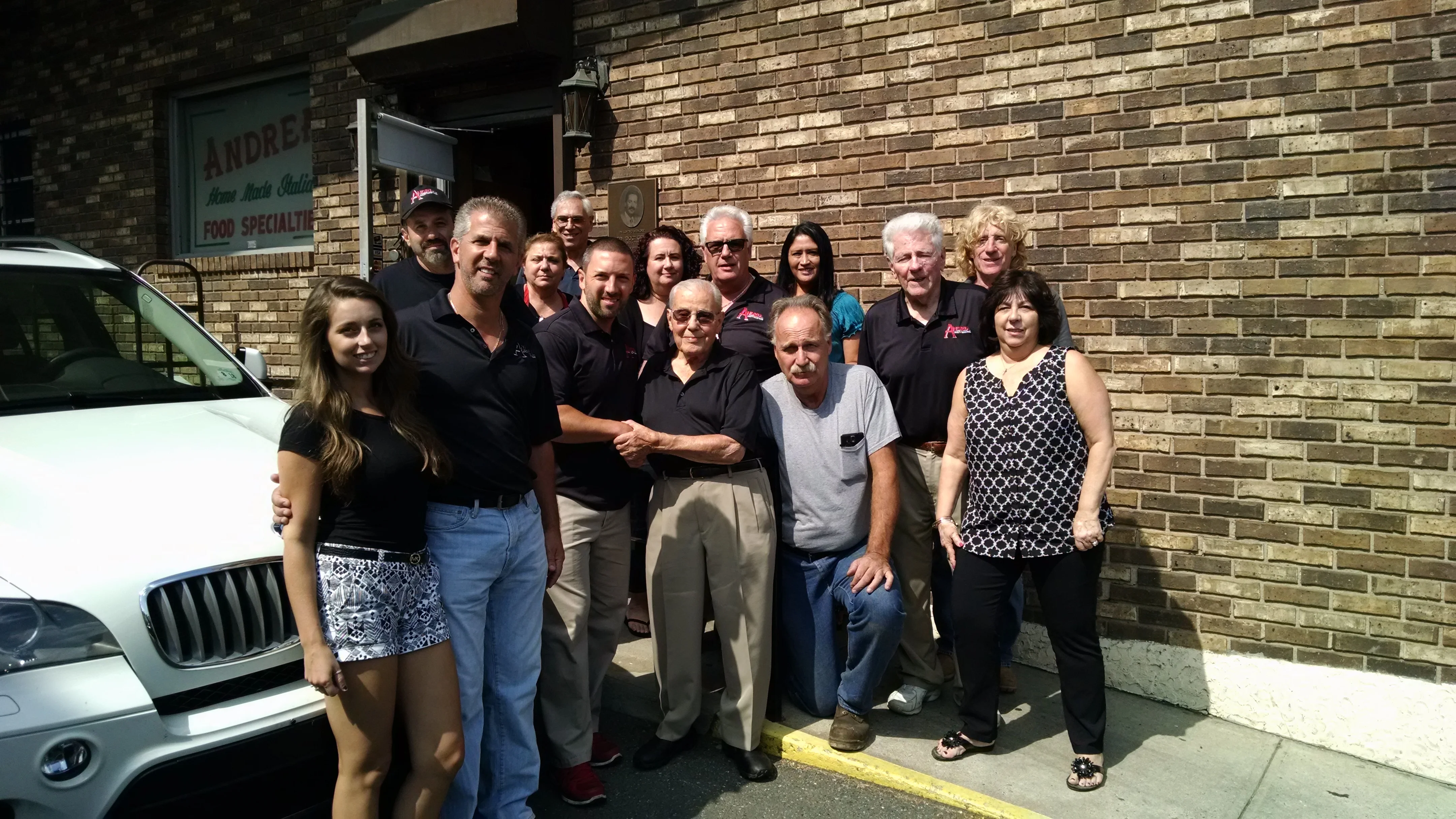 Group photo of restaurant staff outside a brick building