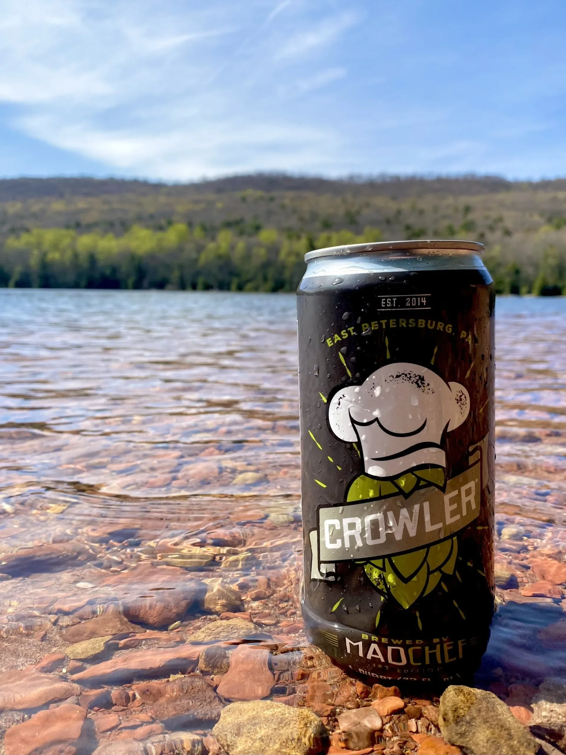 Craft beer crowler by the lake with scenic backdrop