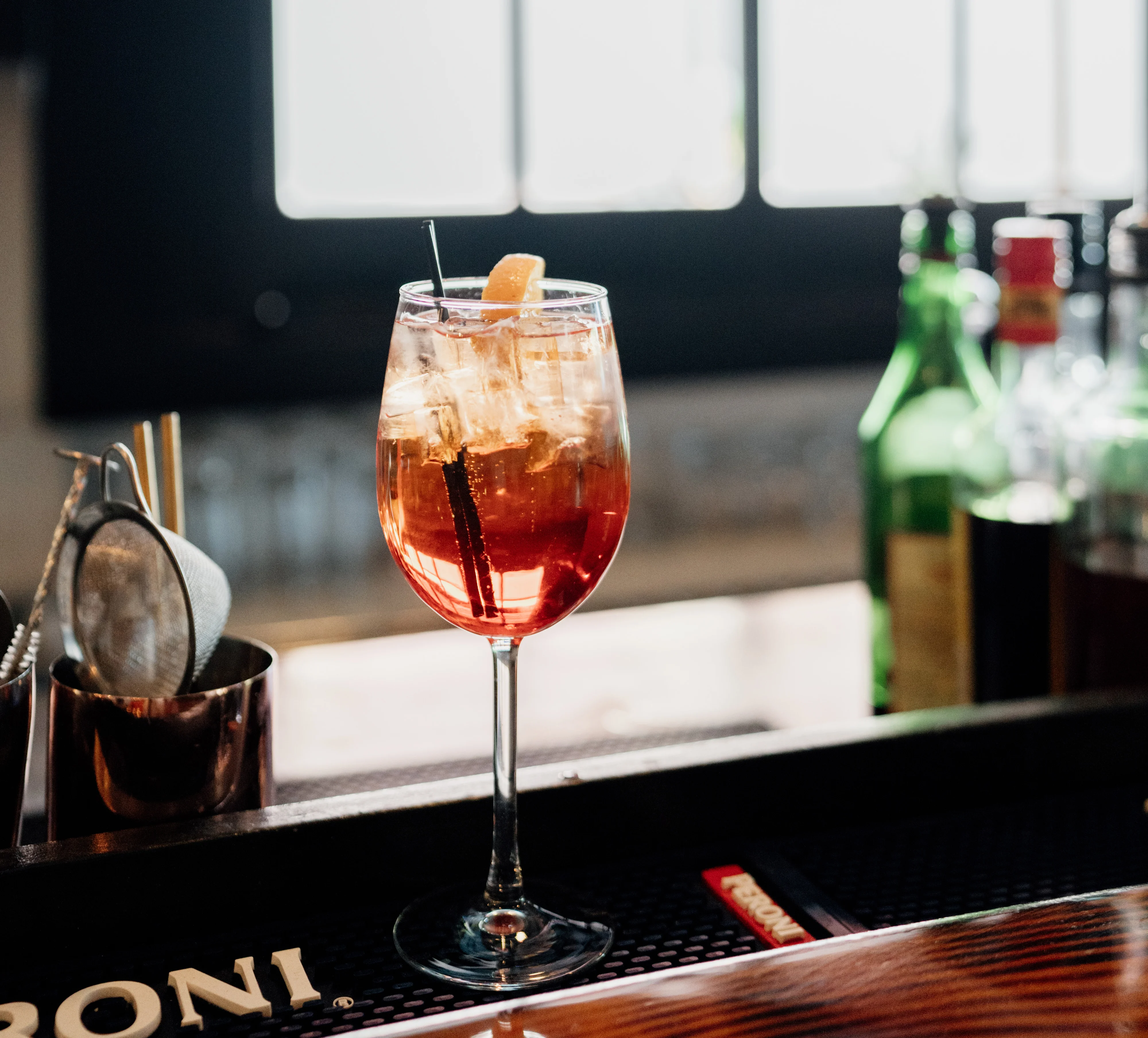 aperol spritz cocktail with ice sitting on bar top