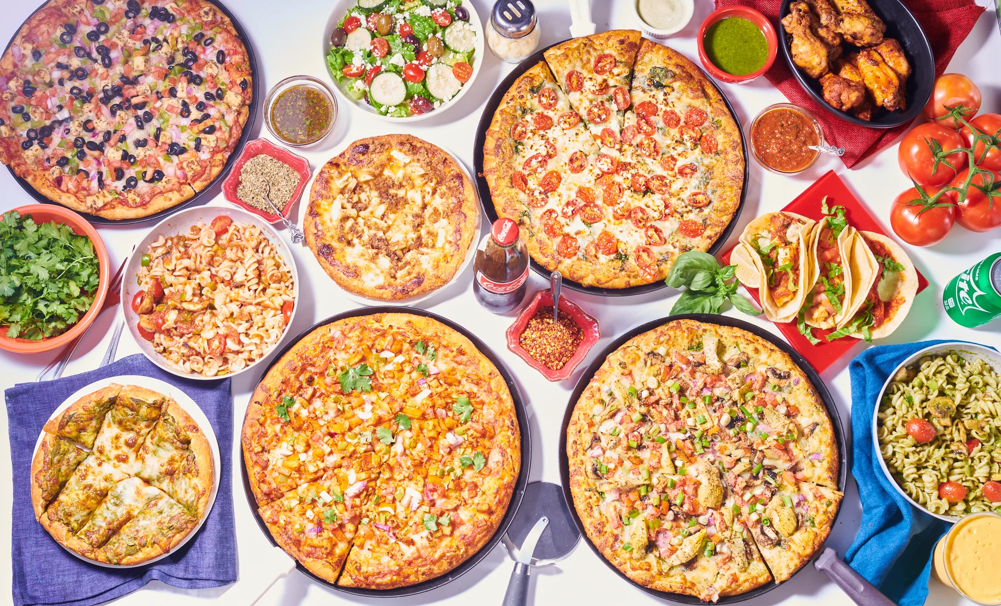 Variety of pizzas and sides in a vibrant spread