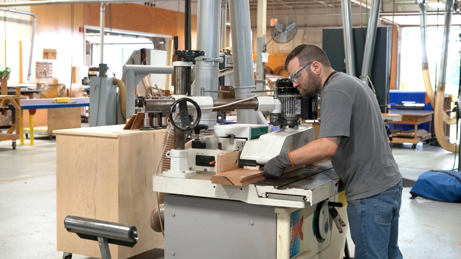 Woodworker operating a machine in a woodworking shop