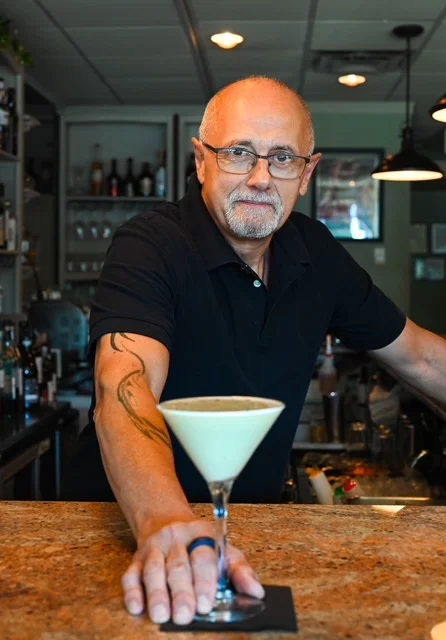 Bartender presenting a signature cocktail at a stylish bar