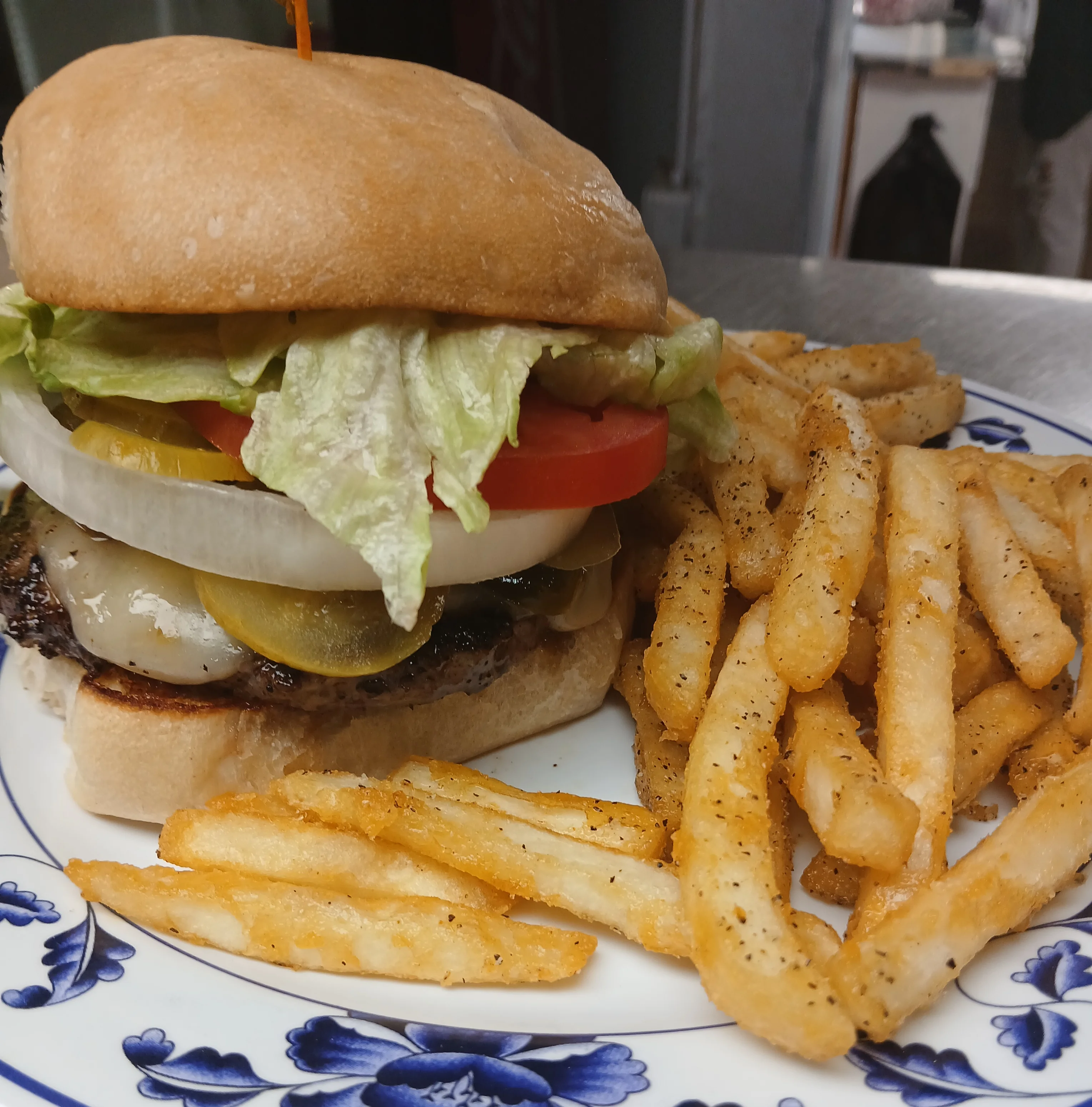 Classic American cheeseburger with lettuce, tomato, pickles, and fries