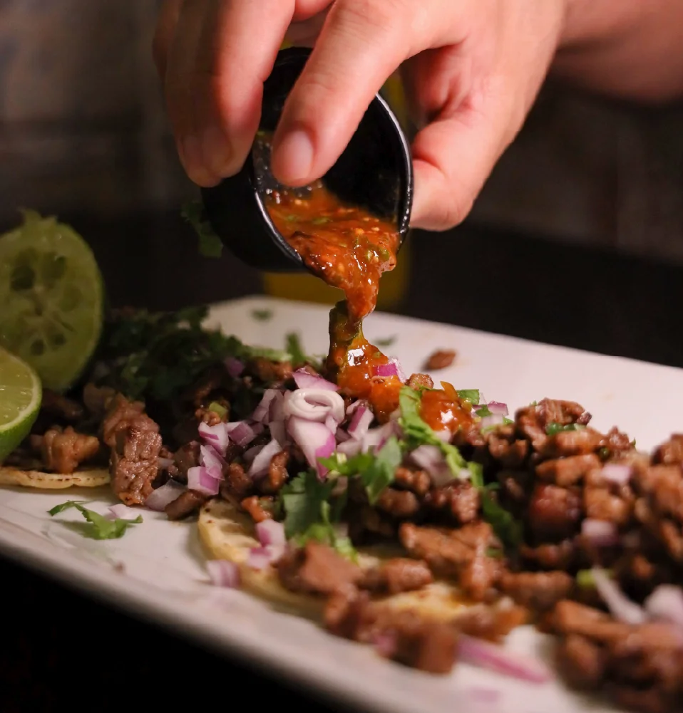 Delicious Mexican tacos al pastor topped with salsa and onions