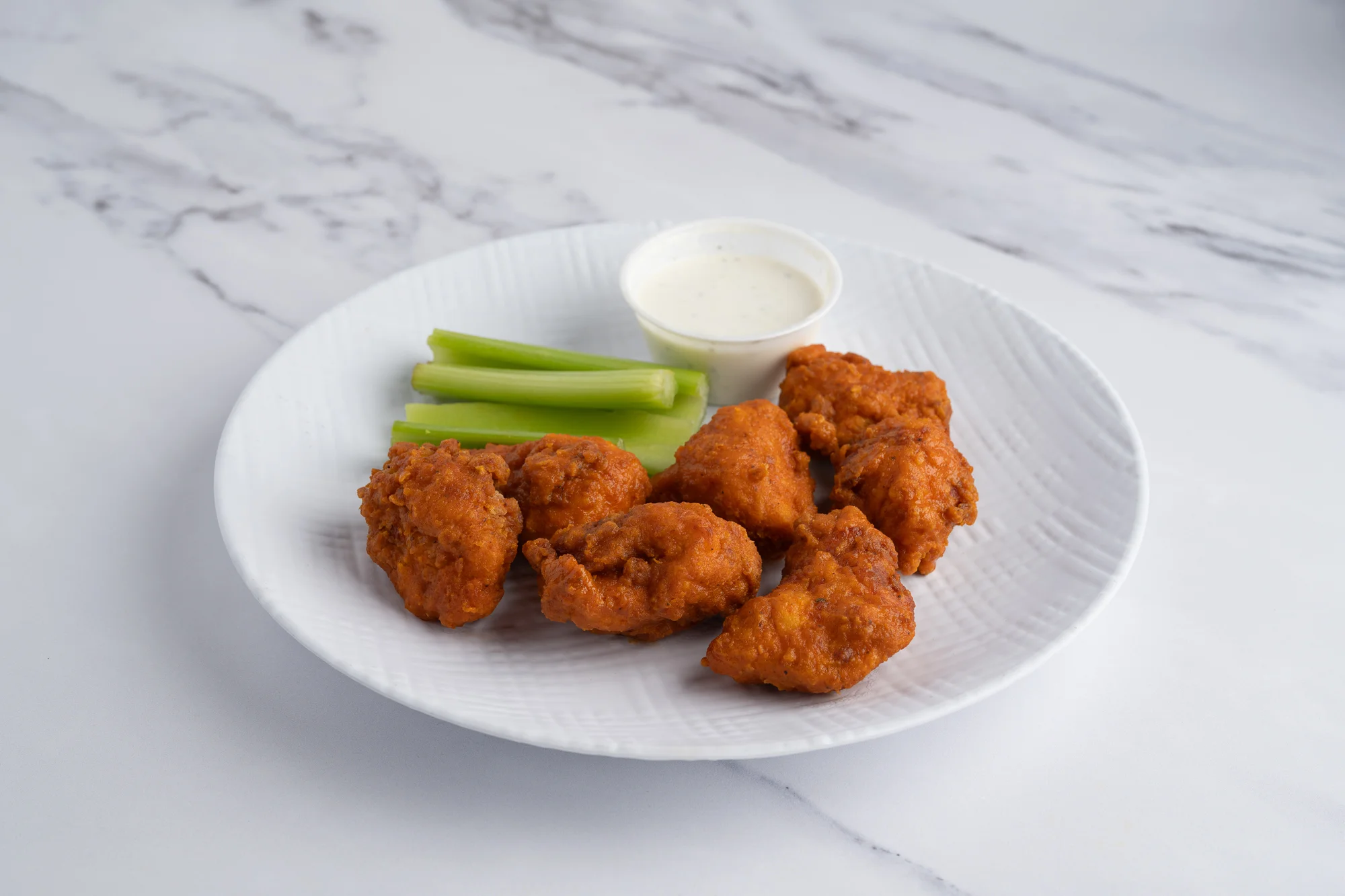 Crispy buffalo chicken wings with celery and ranch dip