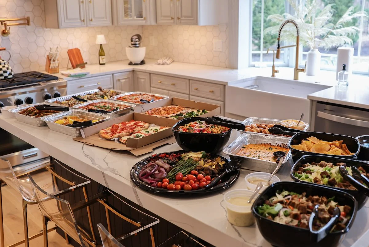 Variety of Italian pizzas and Mediterranean dishes on a kitchen island