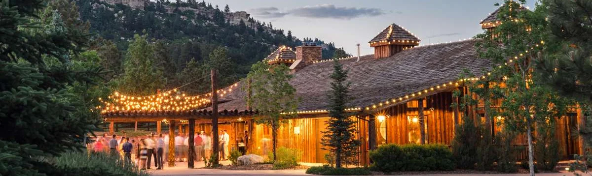 Charming restaurant exterior with string lights and mountain backdrop