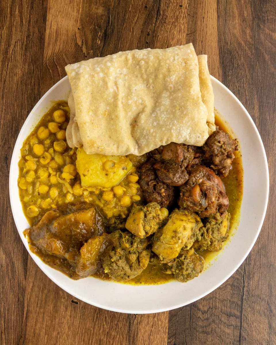 Plate of Nigerian jollof rice with assorted meats and plantains