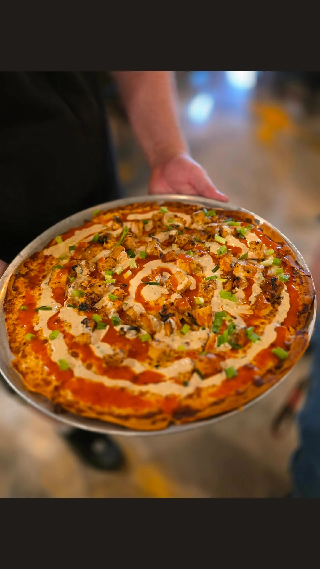 Delicious buffalo chicken pizza with drizzled sauce and fresh toppings