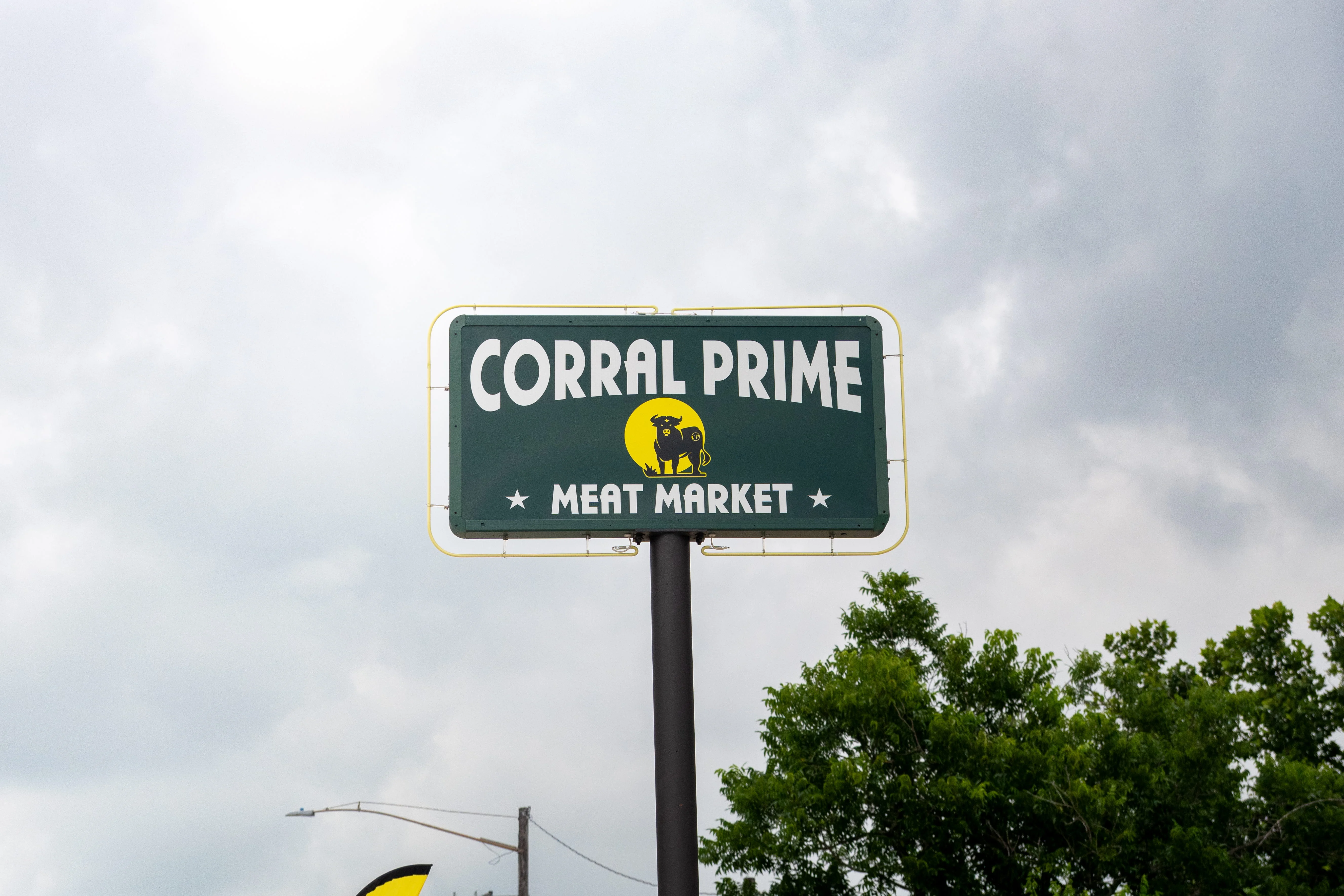 Sign for Corral Prime Meat Market with a cow logo