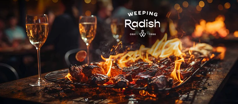 An open fire with Weeping Radish glassware at Firetender in Manteo, NC, the flame the restaurant is named for
