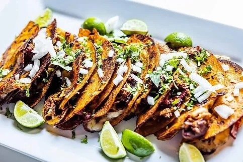 Delicious Mexican street tacos garnished with onions and cilantro
