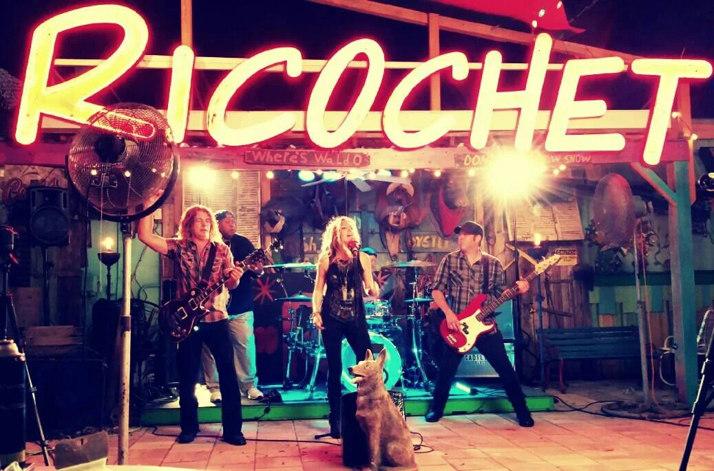 Live band performing at Ricochet restaurant with neon signage