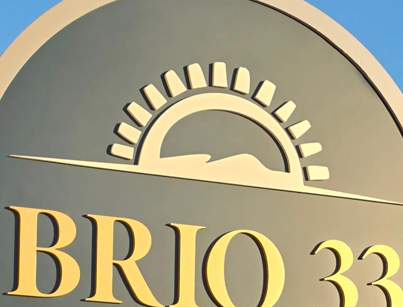 Sign for Brio 33 New England Bistro with a sun design