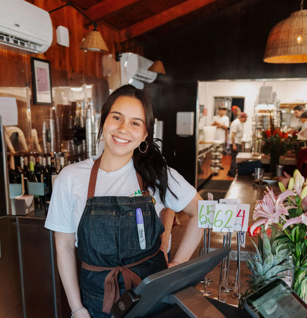 Friendly staff member at a restaurant counter