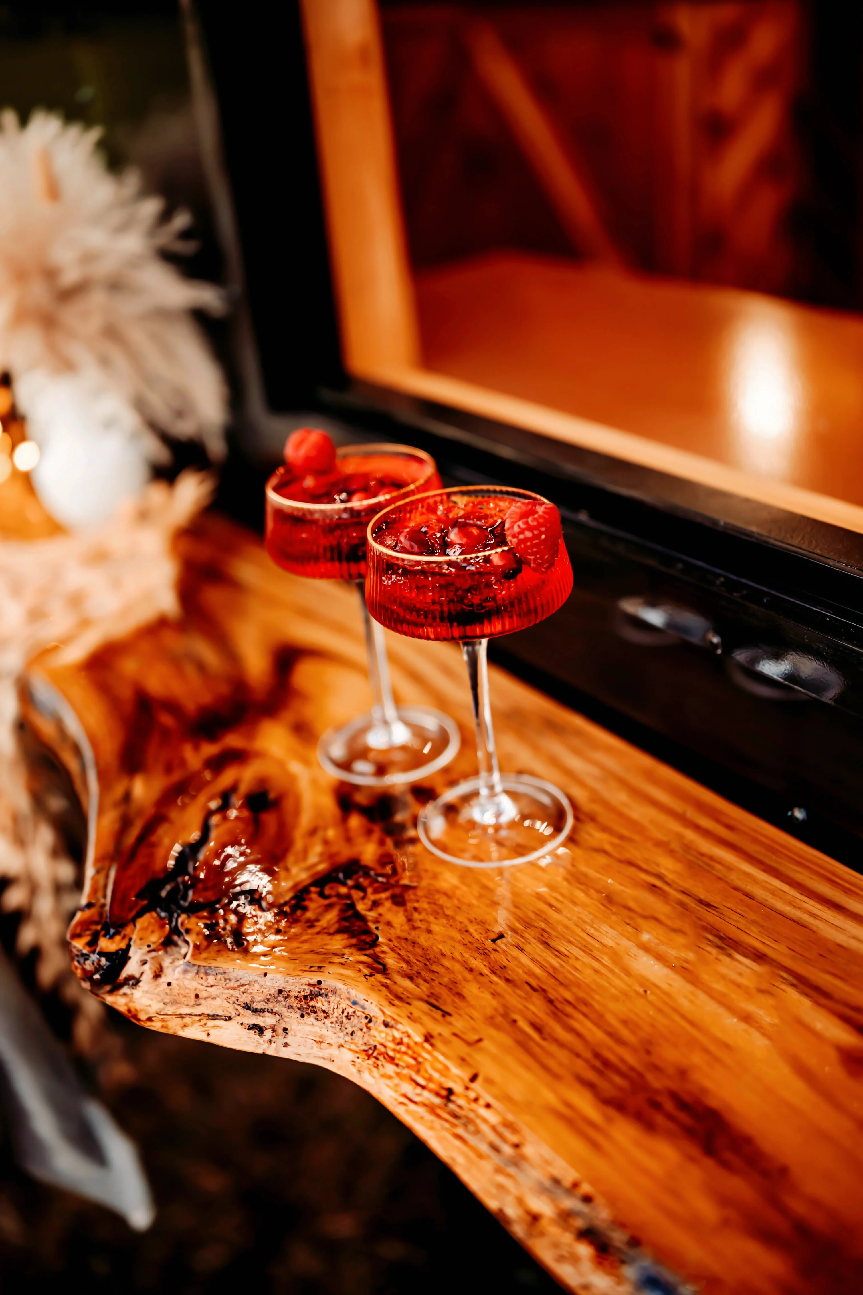 Elegant cocktails with raspberries on a wooden bar