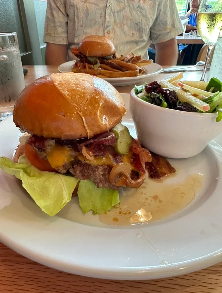 Juicy American cheeseburger with bacon and side salad