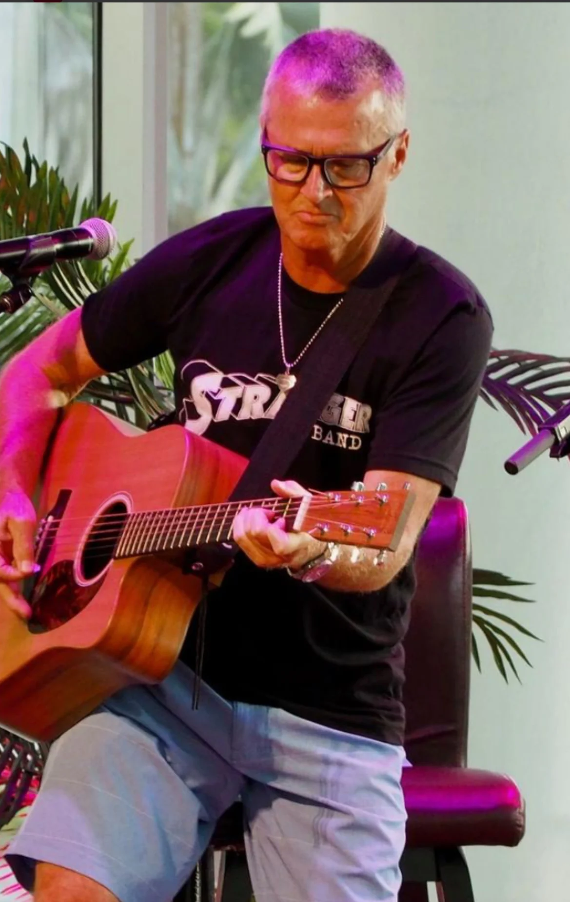 Musician seated with guitar in a rustic outdoor setting