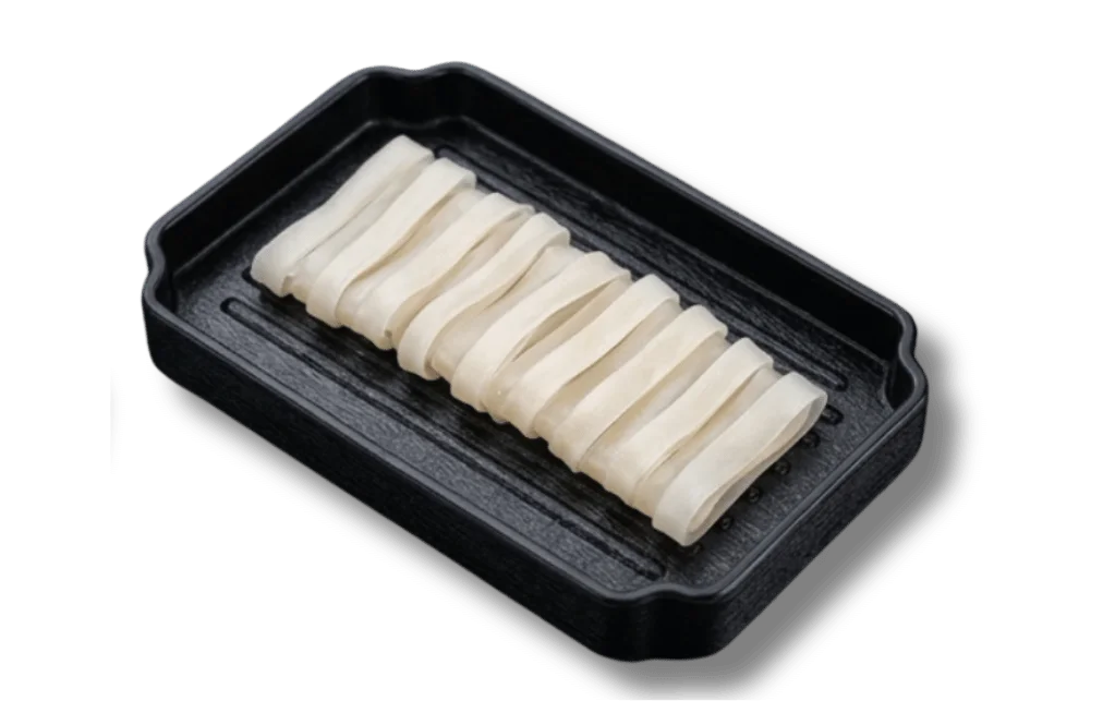Thinly sliced white fish on a black rectangular plate.
