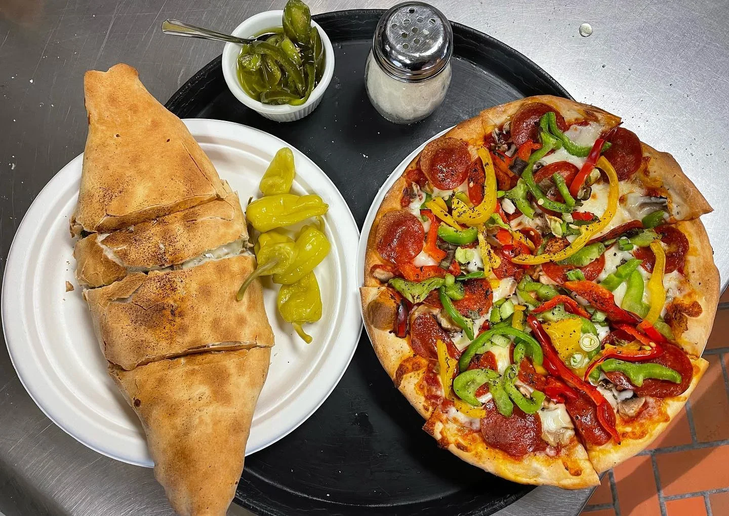 Delicious calzone and pepperoni pizza served with pickled peppers