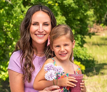 Mother and daughter enjoying a sunny day with flowers and a smoothie