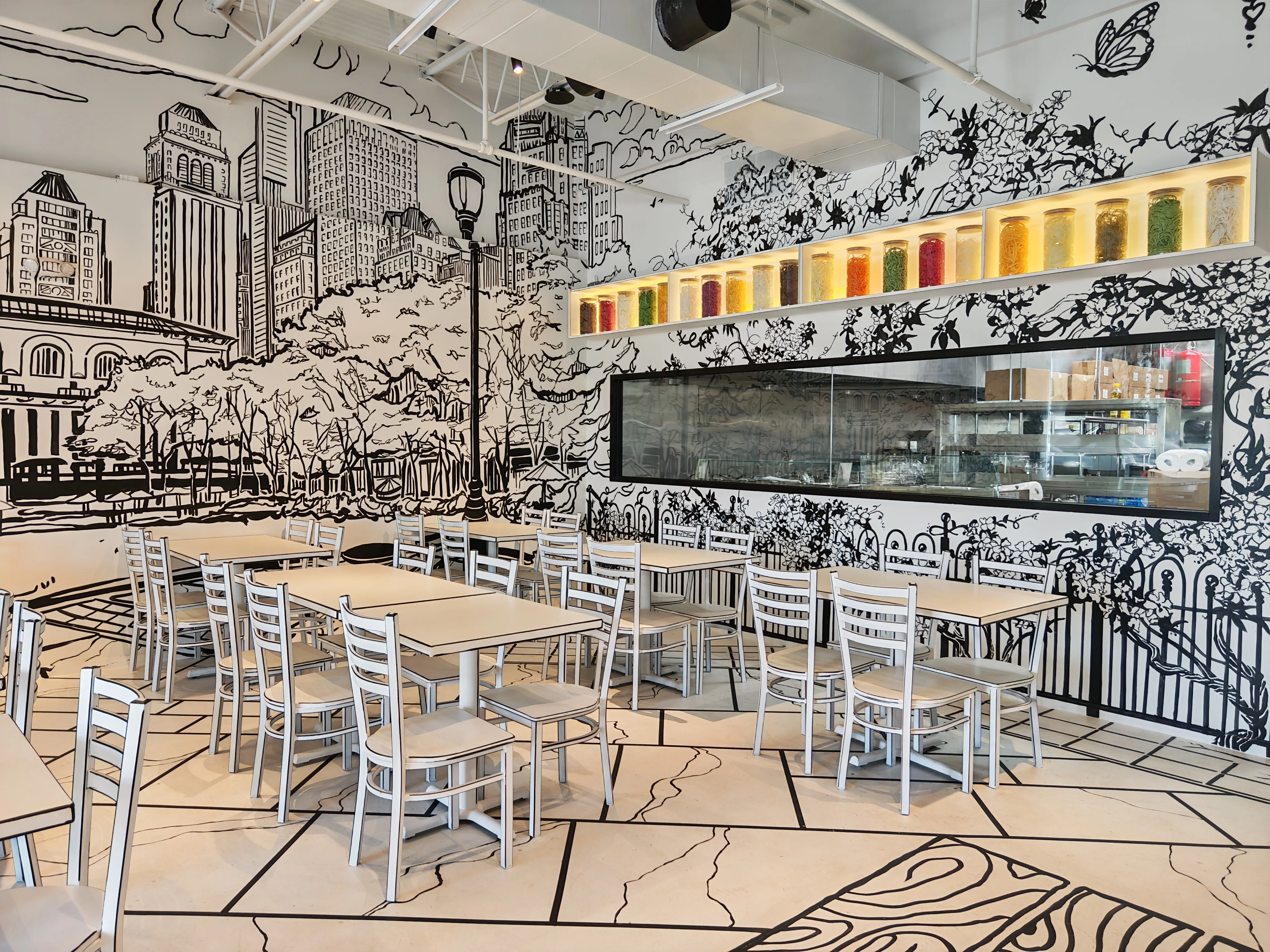 The unique 2-D cartoon-themed interior of Chopsticks Charm, where the walls, tables, and chairs are designed to look like a black and white drawing.