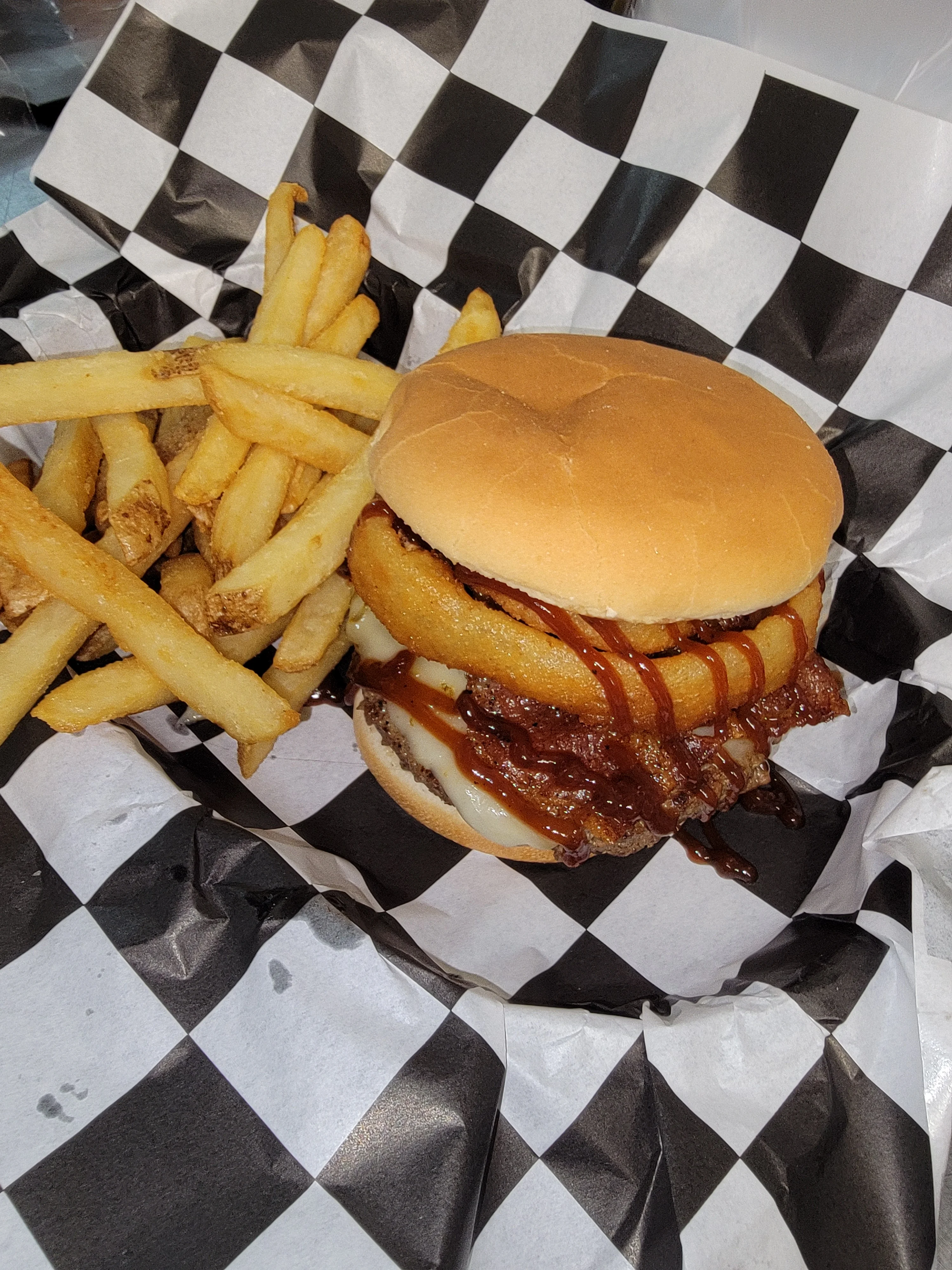 Classic American cheeseburger with onion rings and fries