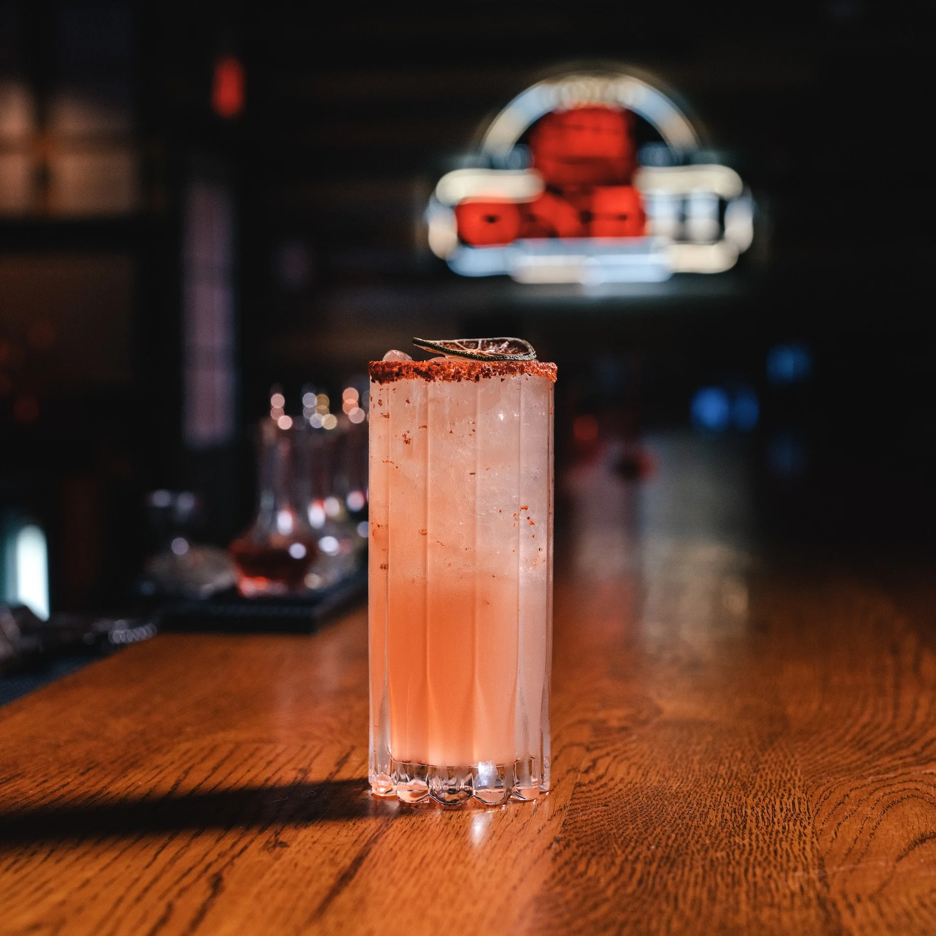 Refreshing cocktail with a spicy rim at a modern bar