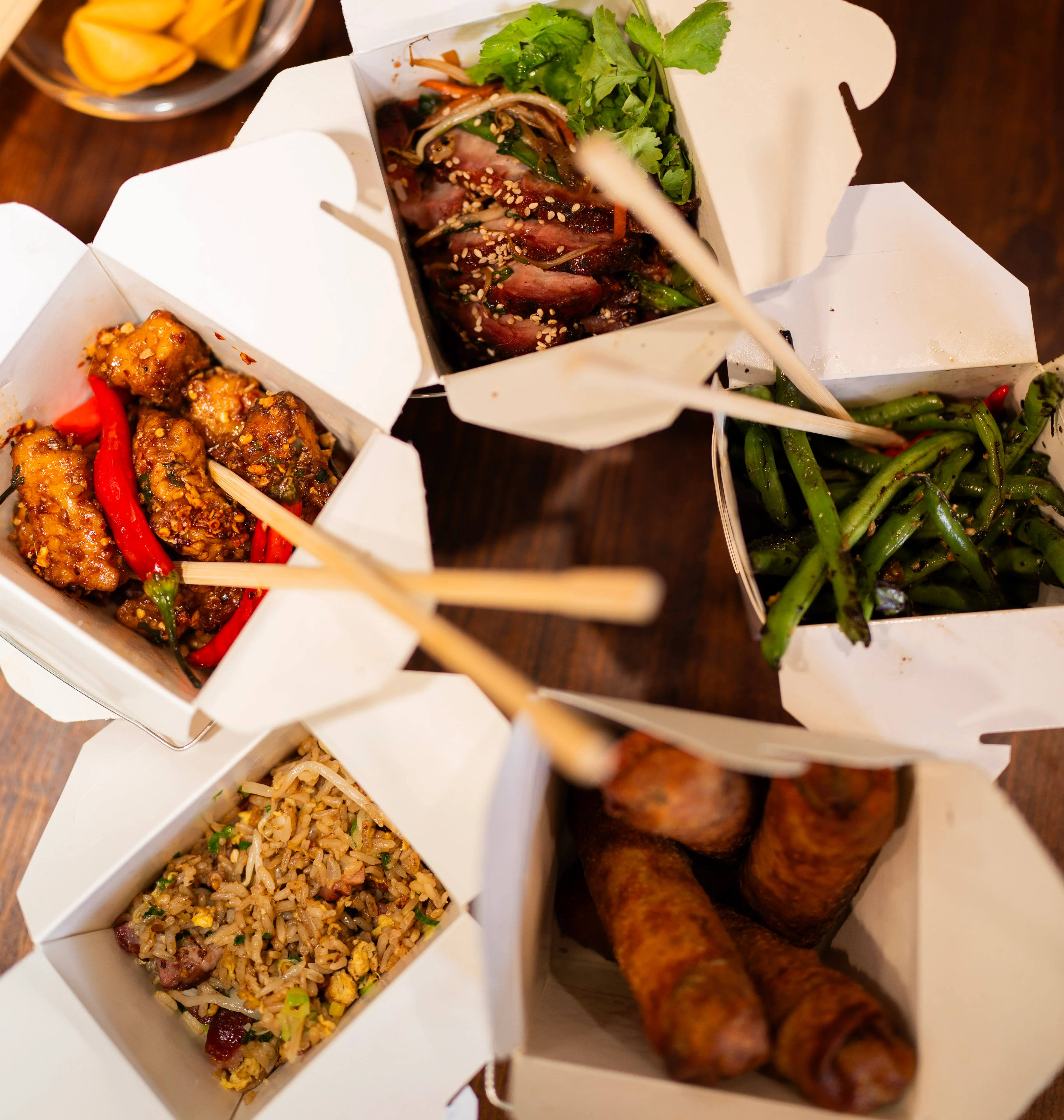 Assorted Chinese takeout dishes in white boxes