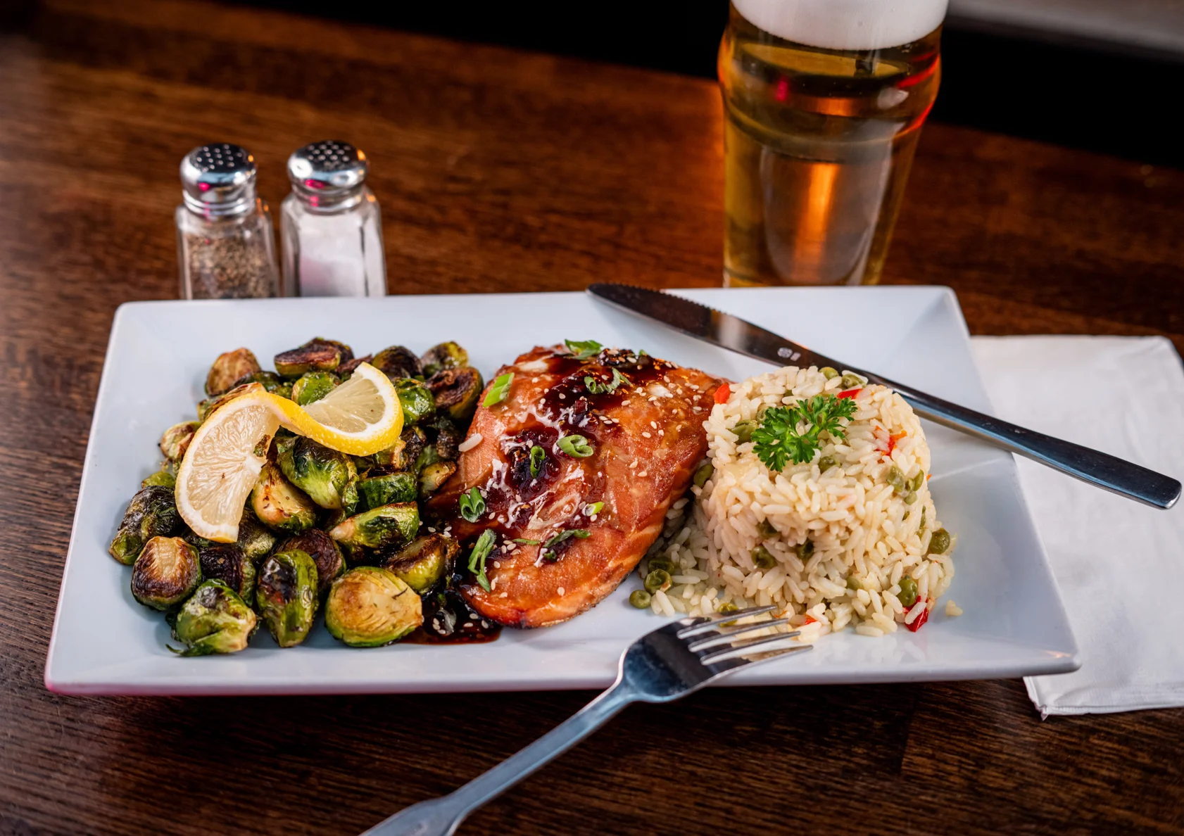 A salmon dinner paired with rice and an assortment of vegetables