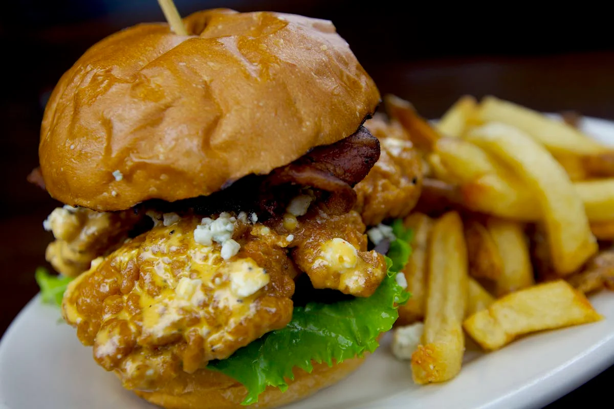 Crispy fried chicken sandwich with bacon and fries