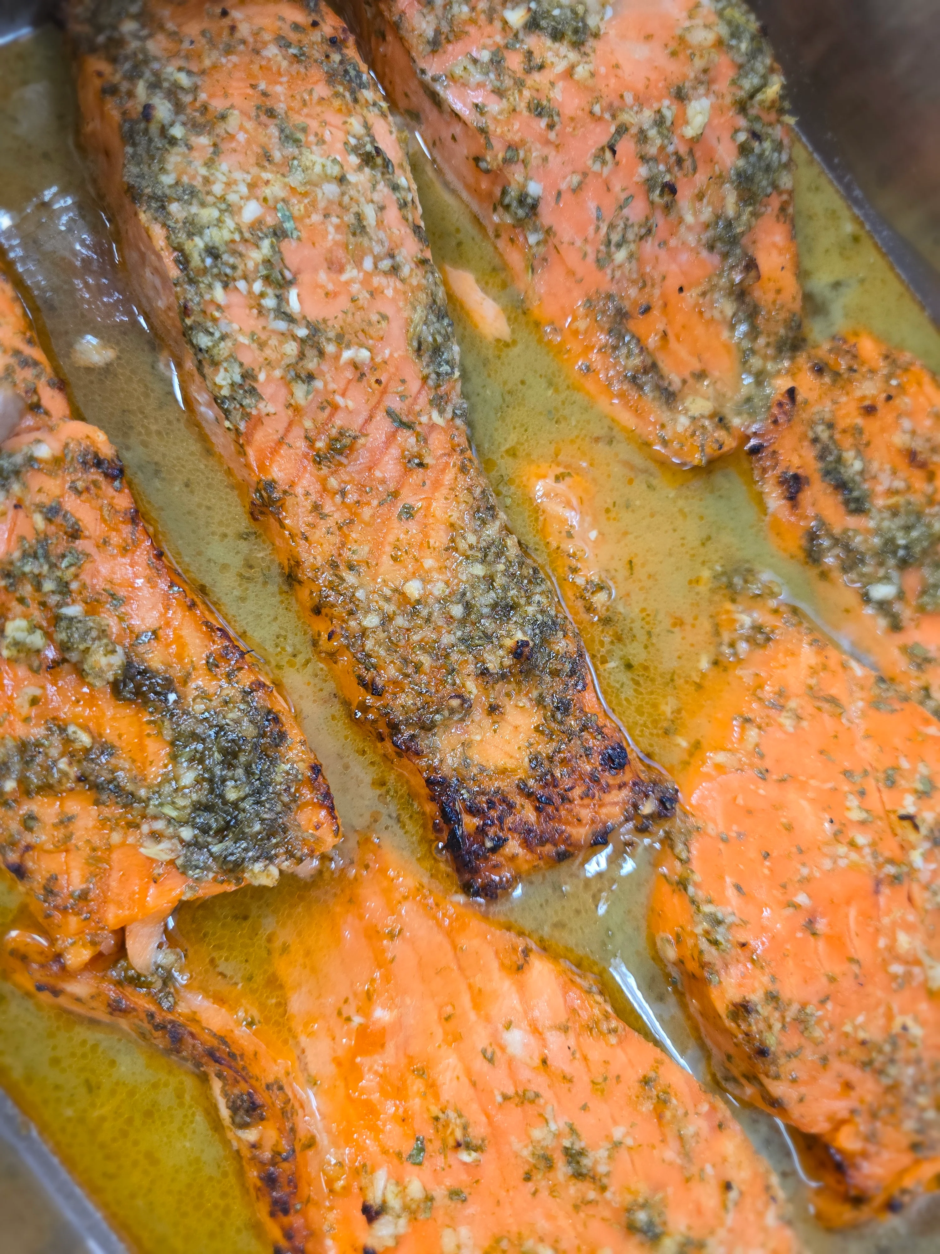 Herb-crusted baked salmon fillets in a savory sauce