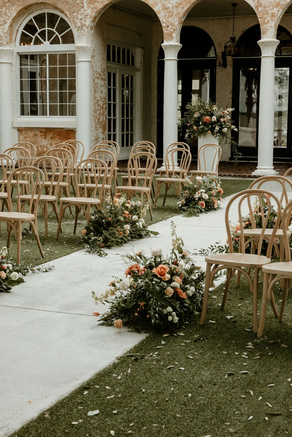 Outdoor wedding setup with chairs and floral arrangements
