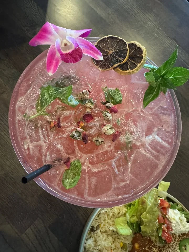 Refreshing pink cocktail garnished with mint and flowers