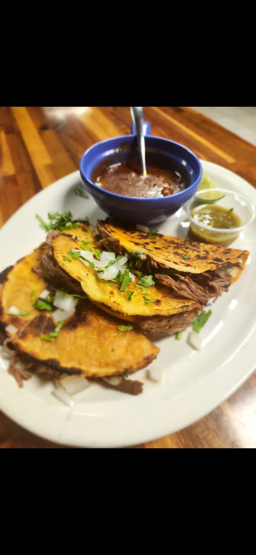 Delicious Mexican birria tacos served with consomé