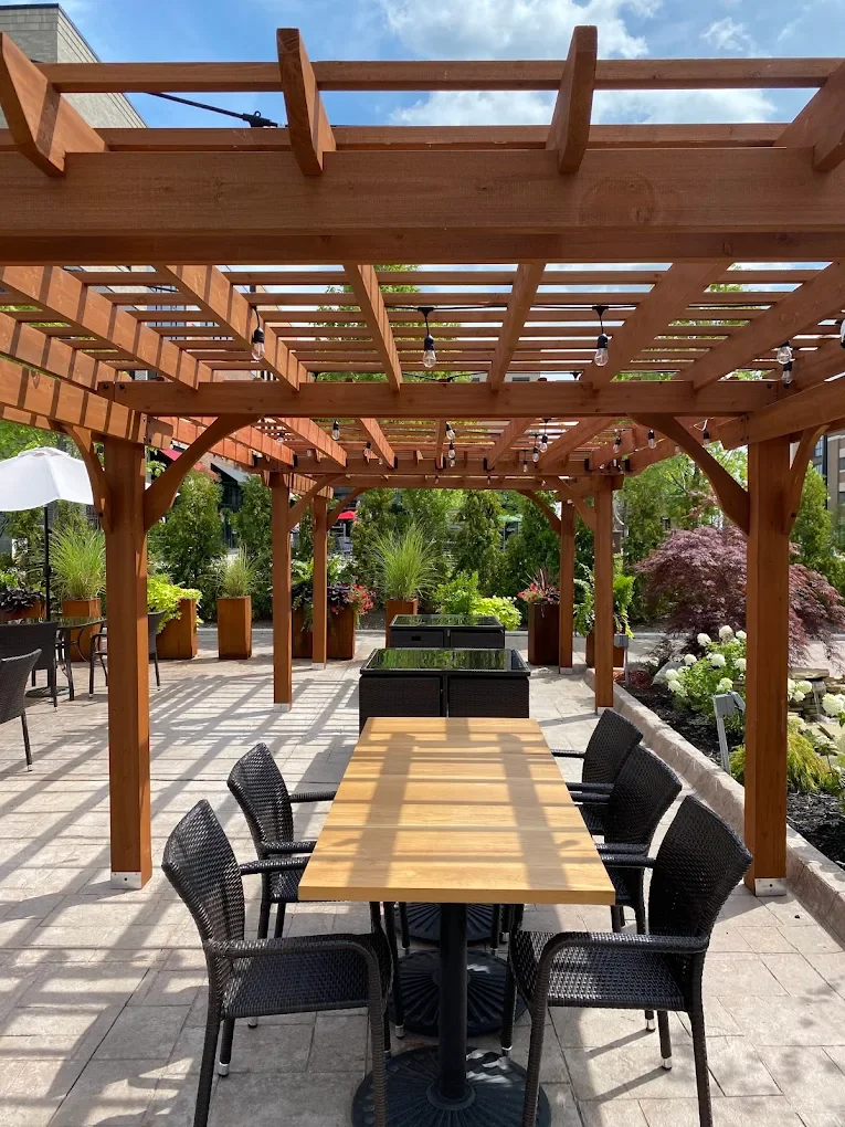 Outdoor dining area with wooden pergola and seating