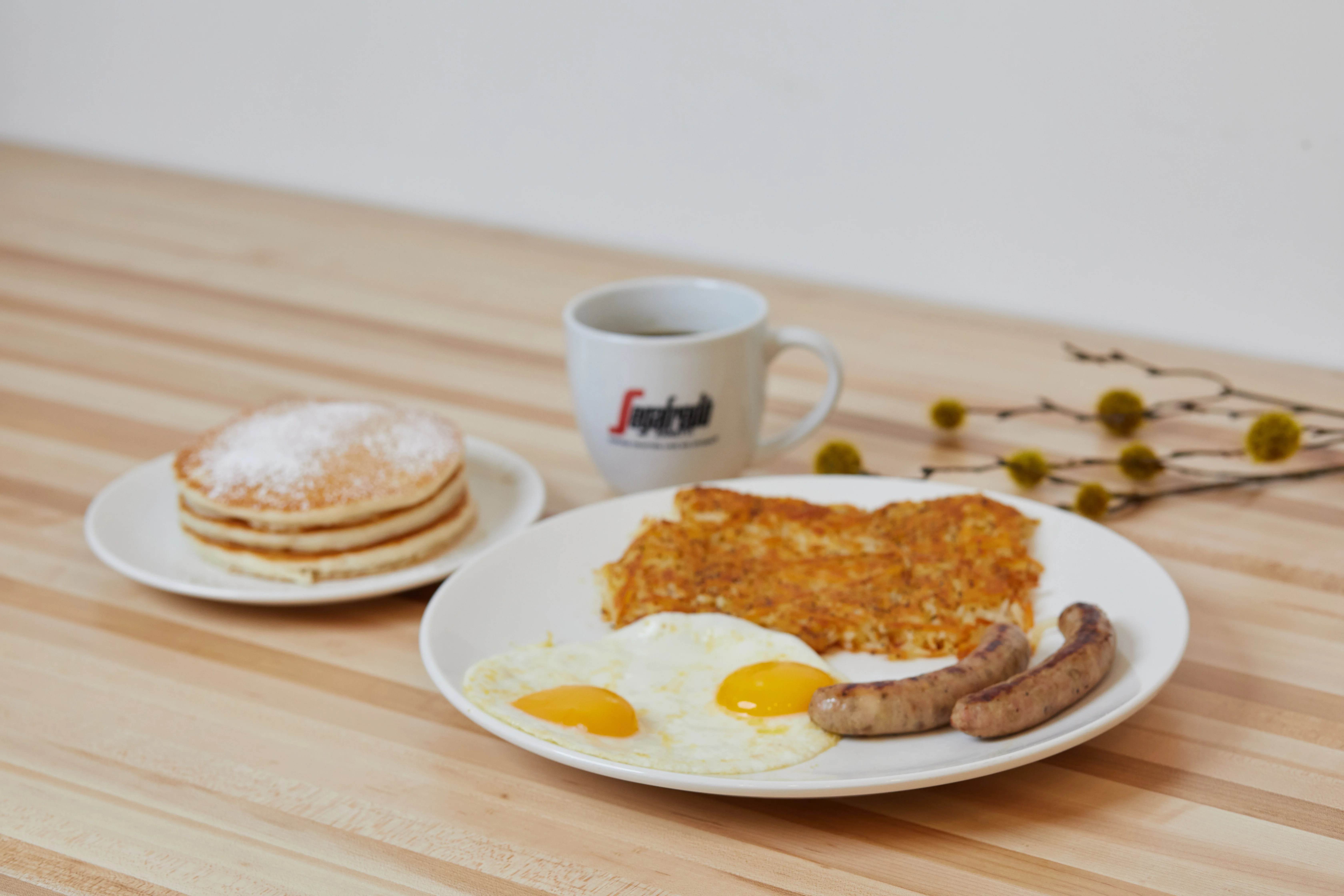 Classic American breakfast with pancakes, eggs, and sausage