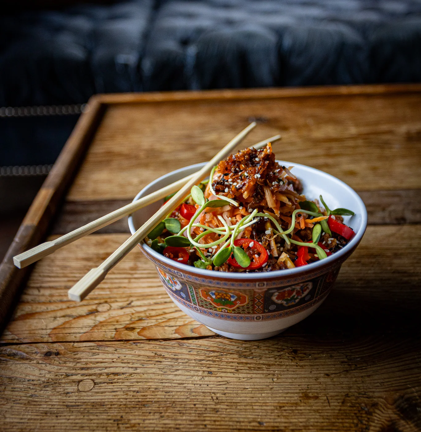 Dan Dan noodles with a comfortable couch in the background