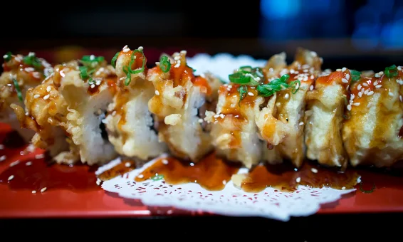 Crispy Japanese tempura sushi roll drizzled with sauce