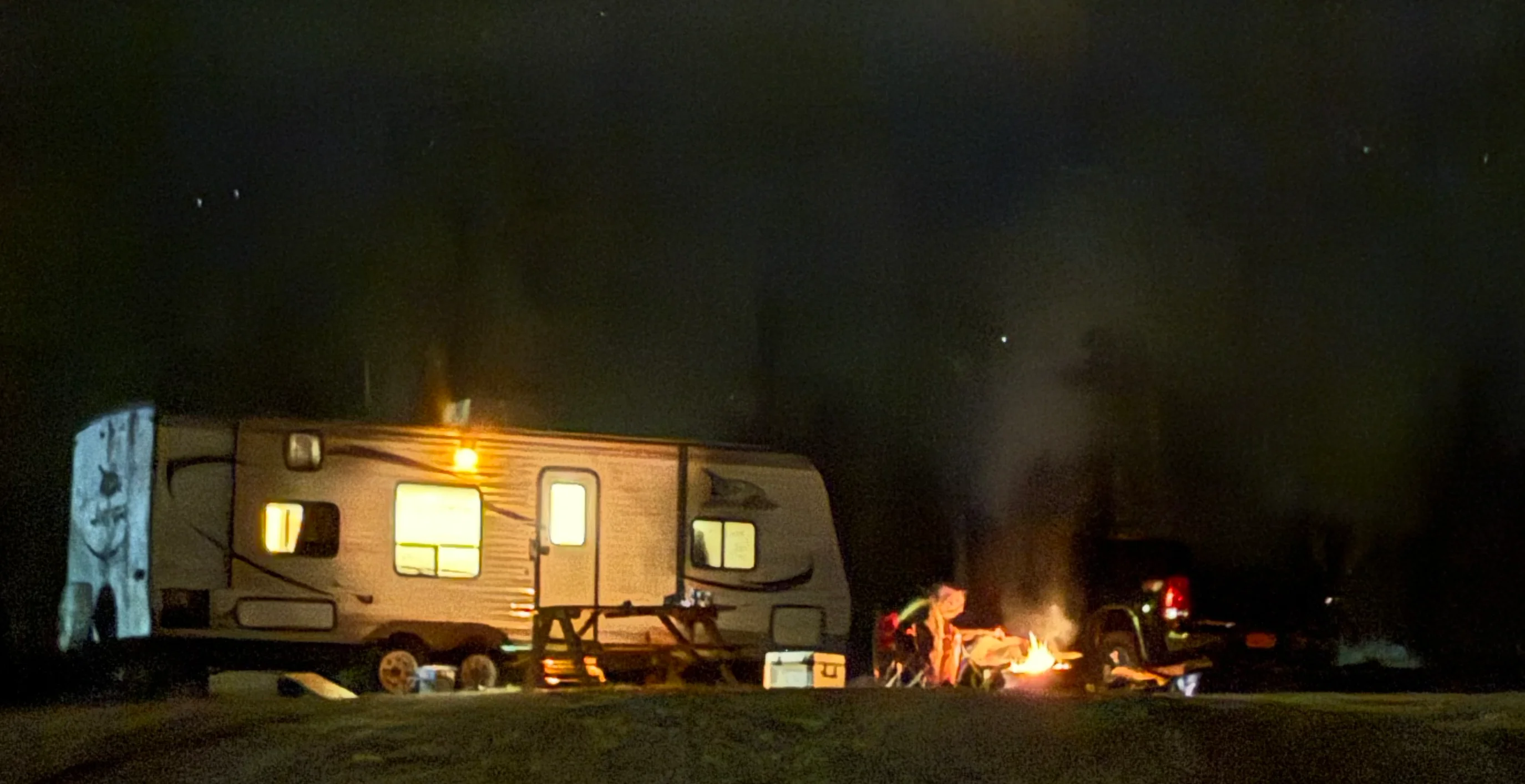 Guests enjoying a fire at Ozark Trails Campground in RV spot 1